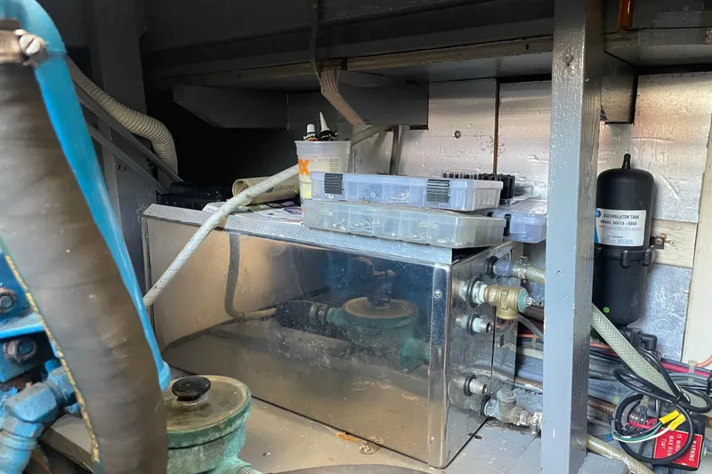 Slide: The Image of Engine room of 1987 Chris-Craft 392 Commander with mechanical components and storage boxes. - 27