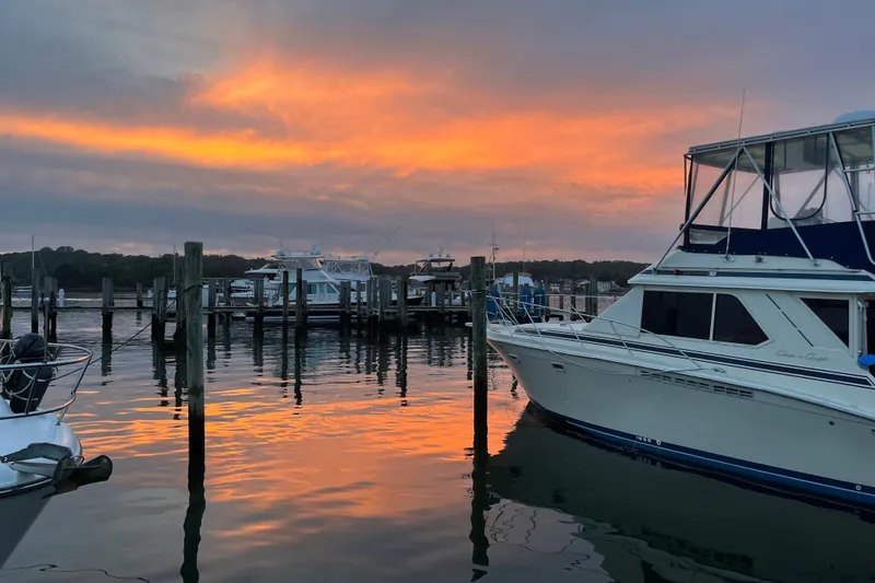 Slide: The Image of 1987 Chris-Craft 392 Commander yacht docked at sunset, reflecting on calm water. - 5