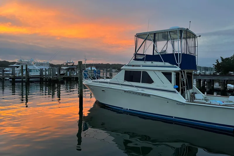 Slide: The Image of 1987 Chris-Craft 392 Commander yacht docked at sunset, reflecting on calm water. - 9