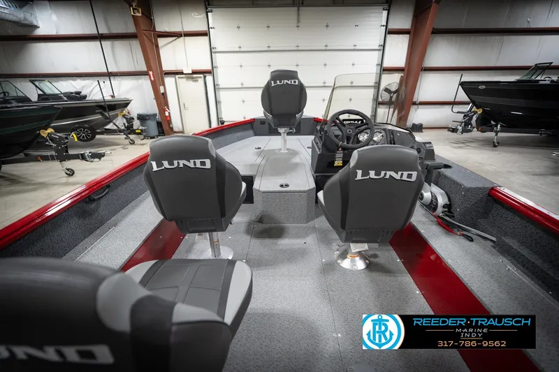 Slide: The Image of 2026 Lund 1800 Explorer Sport boat interior with seating and steering console in a showroom. - 15