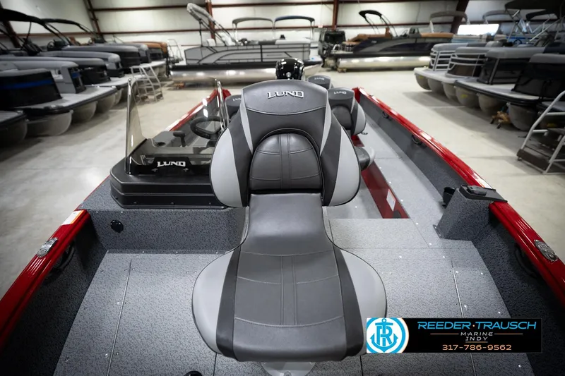 Slide: The Image of 2026 Lund 1800 Explorer Sport boat interior with gray seating in showroom. - 17