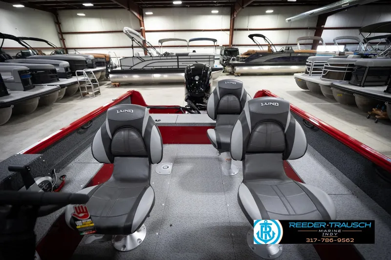 Slide: The Image of 2026 Lund 1800 Explorer Sport boat interior with gray seats in a showroom. - 18