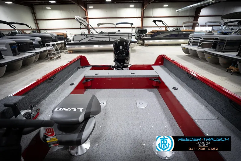 Slide: The Image of 2026 Lund 1800 Explorer Sport boat interior in showroom with pontoon boats. - 20