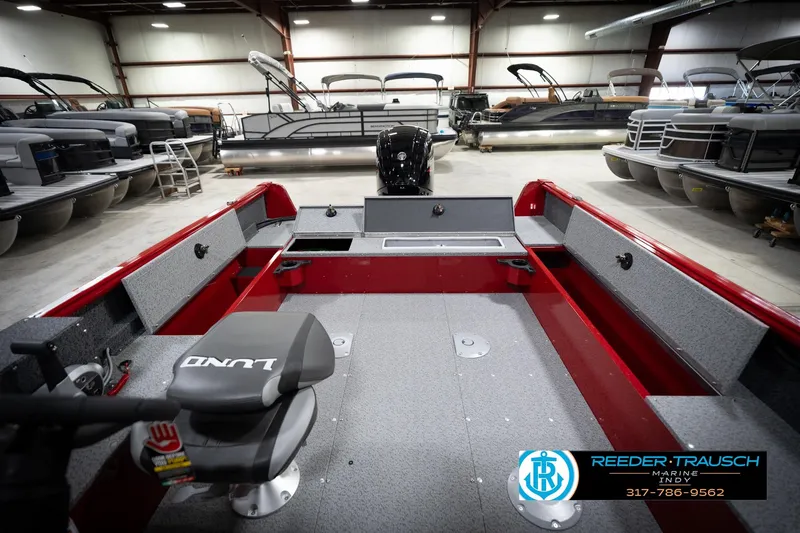 Slide: The Image of 2026 Lund 1800 Explorer Sport boat interior in showroom with pontoon boats. - 21