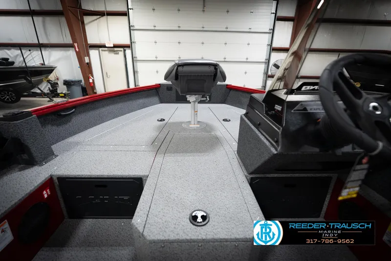 Slide: The Image of 2026 Lund 1800 Explorer Sport boat interior with steering wheel and seating in a showroom. - 23