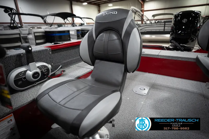 Slide: The Image of 2026 Lund 1800 Explorer Sport boat interior with gray seating and control panel. - 32