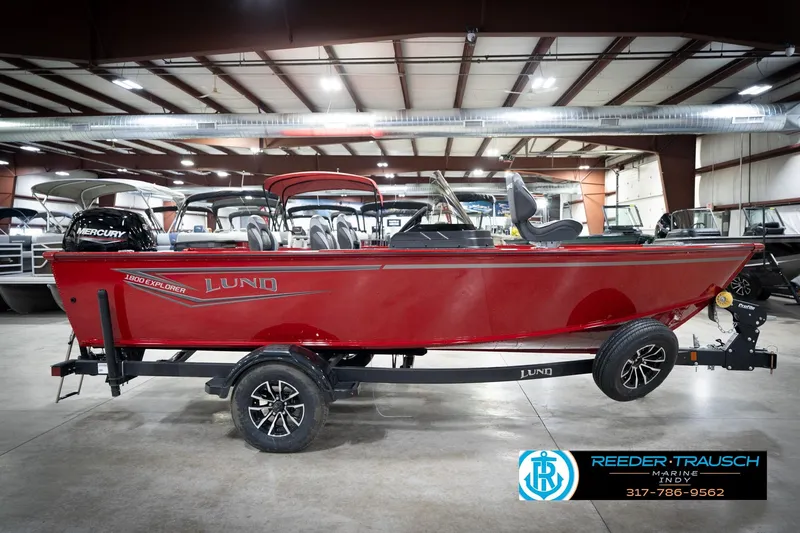 Slide: The Image of 2026 Lund 1800 Explorer Sport boat in showroom, red exterior, on trailer. - 6
