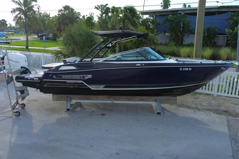 Slide: The Image of 2021 Monterey 275 Super Sport boat on display, parked outdoors with palm trees in the background. - 0