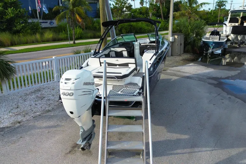 Slide: The Image of 2021 Monterey 275 Super Sport boat with Mercury 400 engine, docked outdoors. - 11