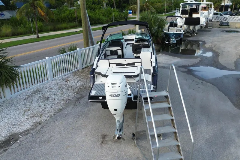Slide: The Image of 2021 Monterey 275 Super Sport boat with powerful 400 engine, docked near a road. - 2
