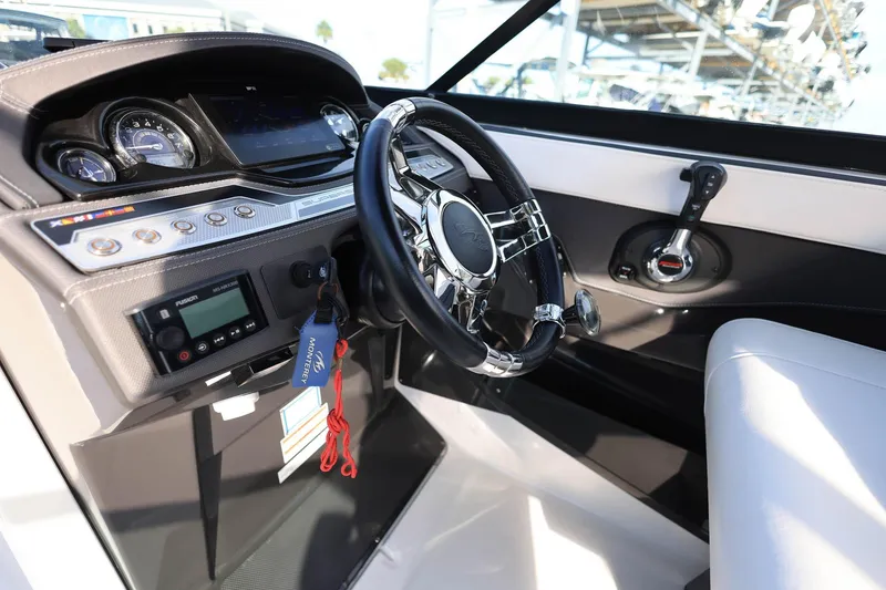 Slide: The Image of 2021 Monterey 275 Super Sport boat dashboard with steering wheel and control panel. - 24