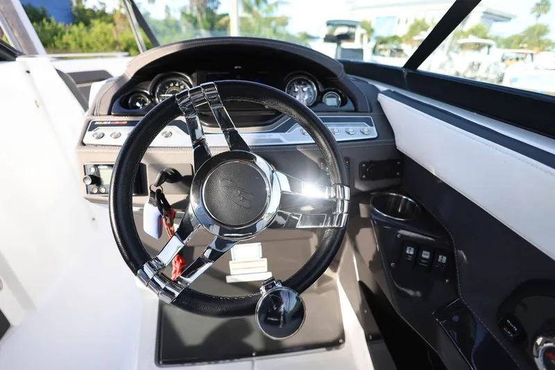 Slide: The Image of 2021 Monterey 275 Super Sport boat dashboard with sleek steering wheel and modern controls. - 25