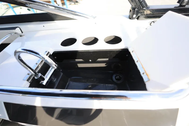 Slide: The Image of 2021 Monterey 275 Super Sport boat interior with open storage compartment and chrome fixtures. - 9