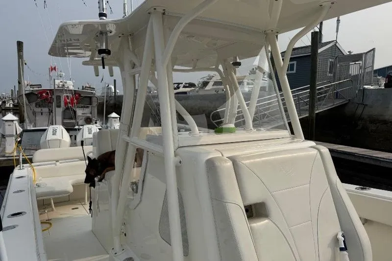 Slide: The Image of 2015 SeaVee 340Z boat docked, featuring a sleek white design and spacious seating. - 10