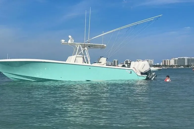 Slide: The Image of 2015 SeaVee 340Z boat in calm waters with city skyline in background. - 2