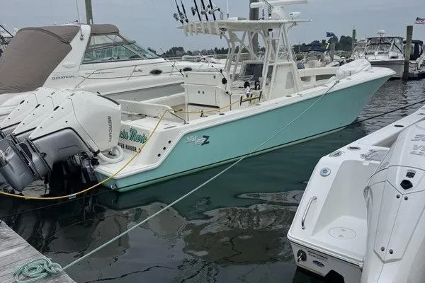 Slide: The Image of 2015 SeaVee 340Z boat docked, featuring triple outboard engines and fishing equipment. - 3