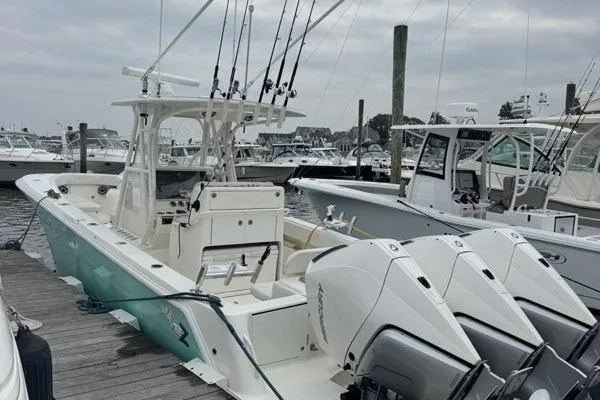 Slide: The Image of 2015 SeaVee 340Z boat docked, featuring multiple fishing rods and powerful outboard engines. - 4