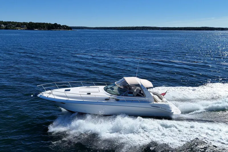 Slide: The Image of 2000 Sea Ray 410 Express Cruiser navigating on open water under clear blue skies. - 1