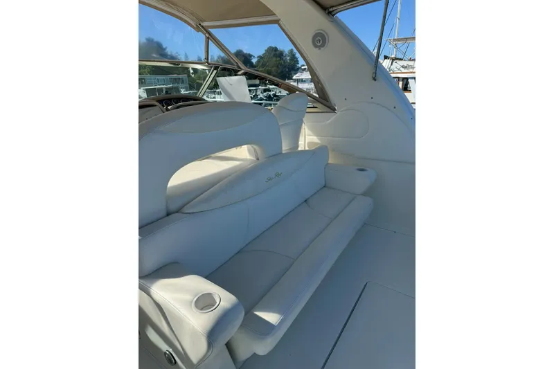 Slide: The Image of 2000 Sea Ray 410 Express Cruiser interior with white seating and cup holders. - 12