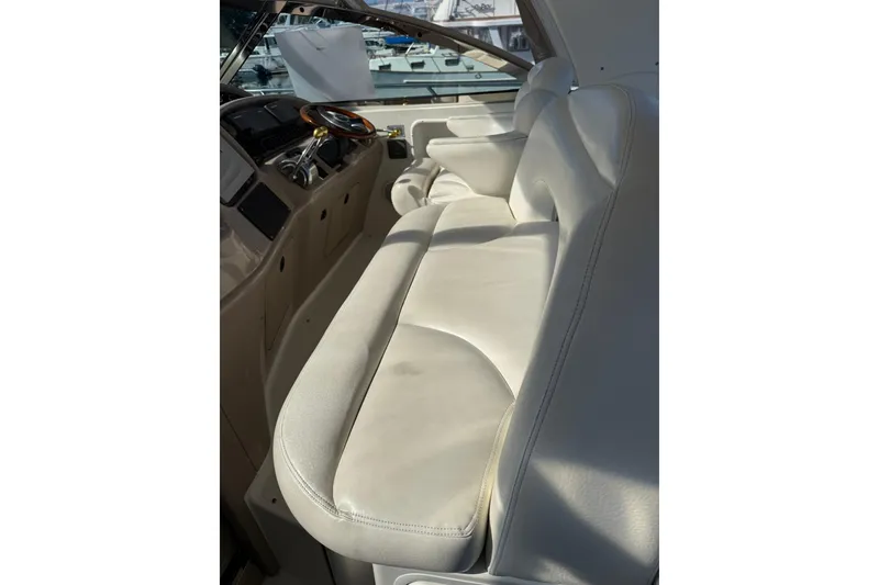 Slide: The Image of 2000 Sea Ray 410 Express Cruiser interior with white leather seating and helm. - 20