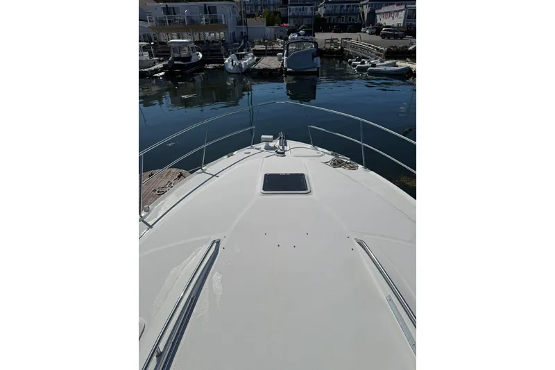 Slide: The Image of 2000 Sea Ray 410 Express Cruiser docked in a marina, view from the bow. - 32