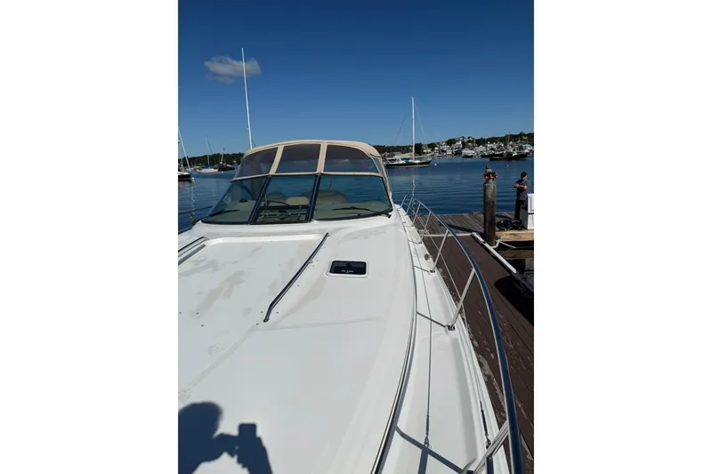 Slide: The Image of 2000 Sea Ray 410 Express Cruiser docked at a marina under clear blue skies. - 36