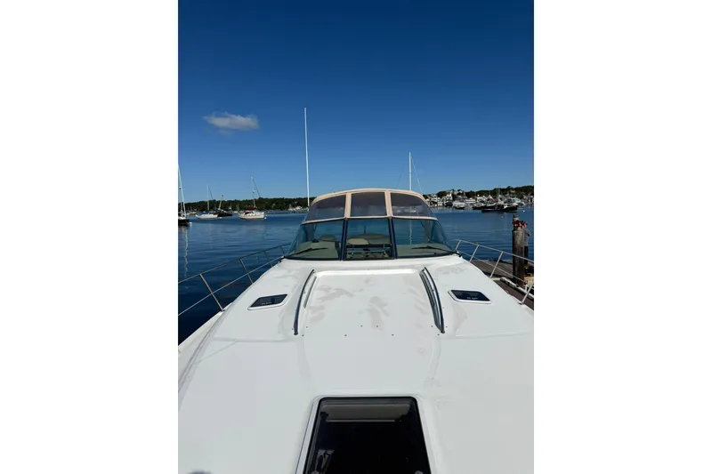 Slide: The Image of 2000 Sea Ray 410 Express Cruiser docked in a serene marina under clear blue skies. - 37