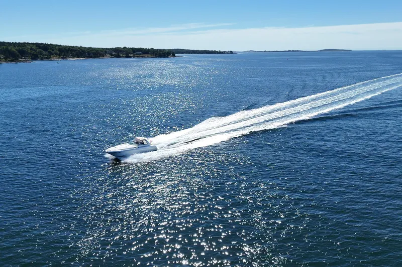 Slide: The Image of 2000 Sea Ray 410 Express Cruiser speeding across a sparkling blue ocean. - 5