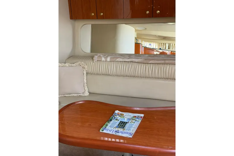 Slide: The Image of Interior of 2000 Sea Ray 410 Express Cruiser with wooden table and cushioned seating. - 57
