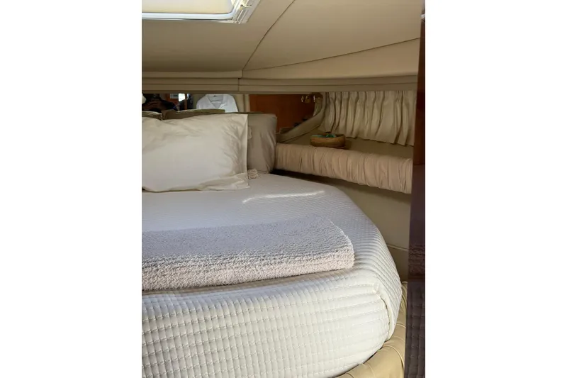 Slide: The Image of Interior cabin of 2000 Sea Ray 410 Express Cruiser with cozy bedding and soft lighting. - 67