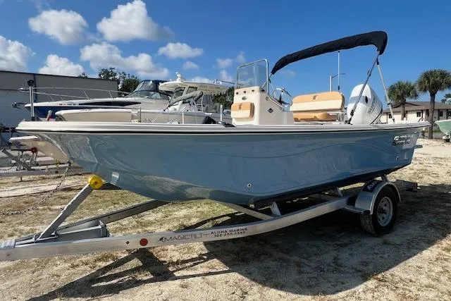 The Image of 2026 Carolina Skiff 19 LS boat on trailer, parked outdoors under blue sky. - 1