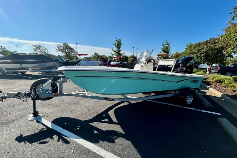 Slide: The Image of 2026 Mako Pro Skiff 17 CC boat on trailer in parking lot, sunny day. - 2