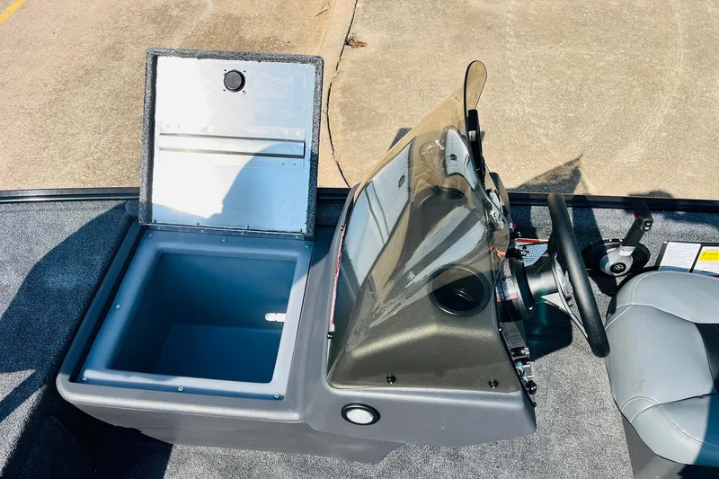 Slide: The Image of 2026 Tracker Bass Tracker Classic XL boat interior with open storage compartment and steering console. - 10