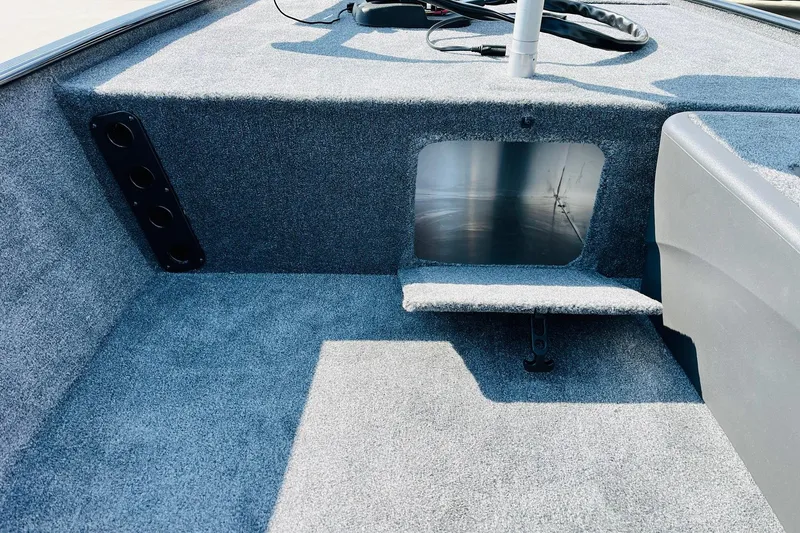 Slide: The Image of 2026 Tracker Bass Tracker Classic XL boat interior with carpeted storage compartment. - 13