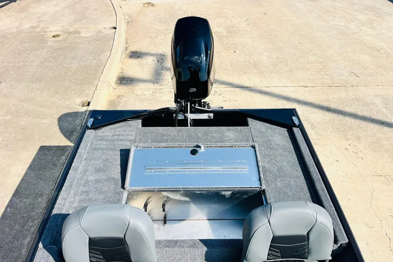 Slide: The Image of 2026 Tracker Bass Tracker Classic XL boat interior with motor, gray seats, and storage compartment. - 25