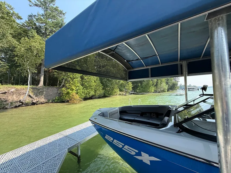 Slide: The Image of 2025 Yamaha Boats 255 XD on a serene lake, surrounded by lush greenery. - 2