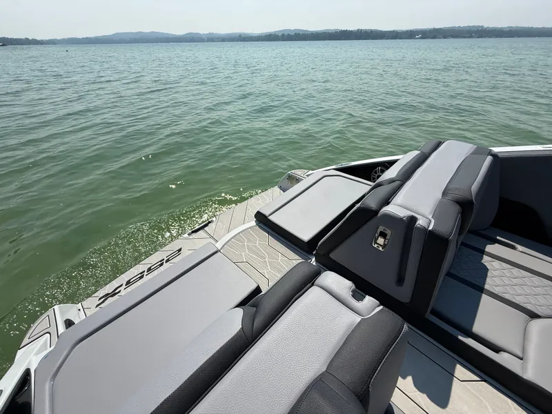 Slide: The Image of 2025 Yamaha Boats 255 XD in blue, cruising on a serene lake with lush greenery. - 3