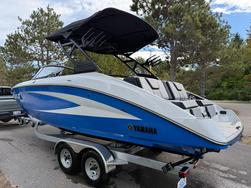 Slide: The Image of 2025 Yamaha Boats 255 XD on trailer, blue and white design, parked outdoors. - 31