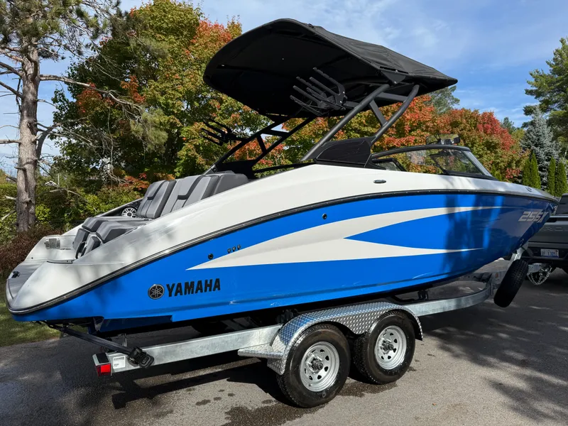 Slide: The Image of 2025 Yamaha Boats 255 XD in blue and white on a trailer, surrounded by autumn trees. - 33