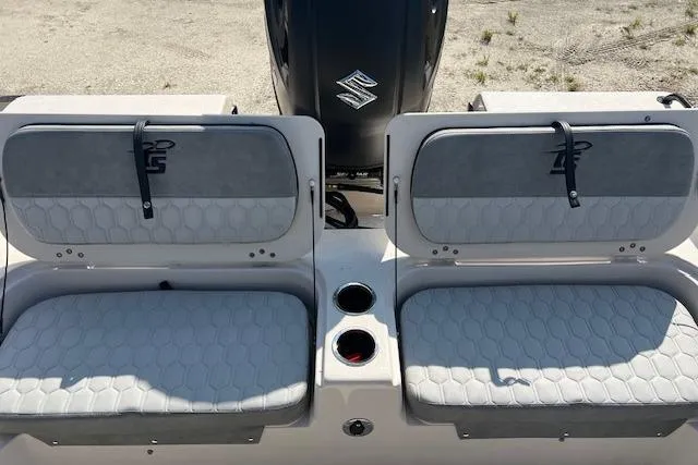Slide: The Image of 2026 Carolina Skiff 21 Ultra Elite boat seats with cup holders and engine in background. - 2