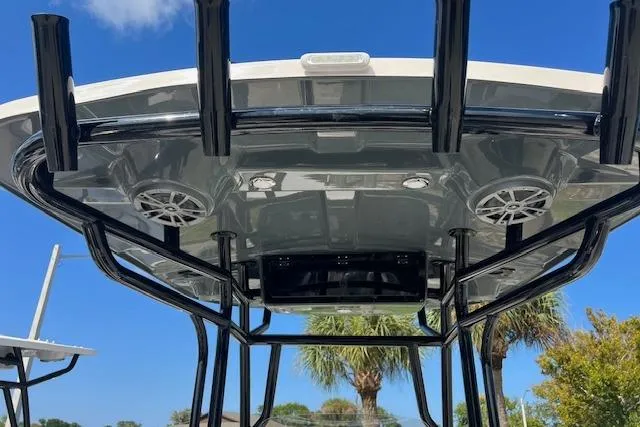 Slide: The Image of 2026 Carolina Skiff 23 LS boat with T-top and speakers against blue sky. - 4