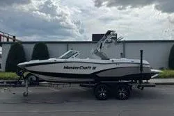 Slide: The Image of 2014 MasterCraft X10 boat on trailer, parked outdoors under cloudy sky. - 14