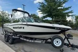 Slide: The Image of 2014 MasterCraft X10 boat on trailer, parked outdoors. - 2