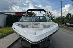 Slide: The Image of 2014 MasterCraft X10 boat with sleek design, parked outdoors under a cloudy sky. - 6