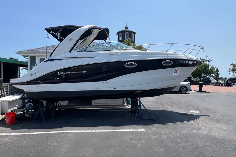 The Image of 2016 Crownline 264 CR boat on display at a marina, elevated on stands. - 0