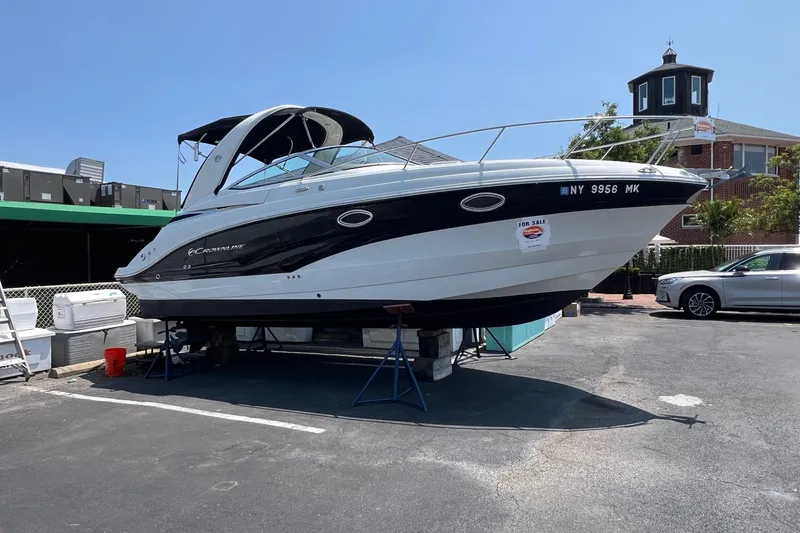 Slide: The Image of 2016 Crownline 264 CR boat on display, for sale, in a parking lot setting. - 1