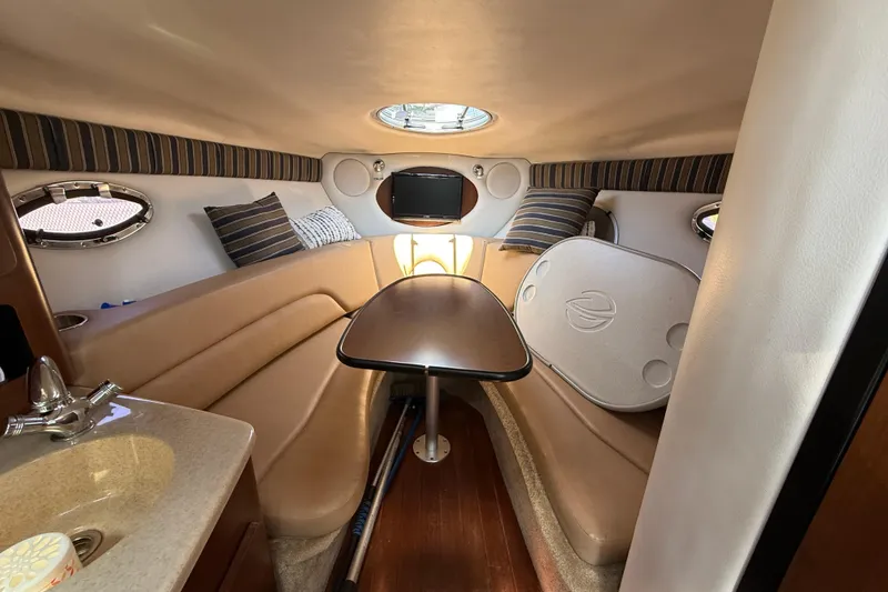 Slide: The Image of Interior of 2016 Crownline 264 CR boat with seating, table, and portholes. - 17