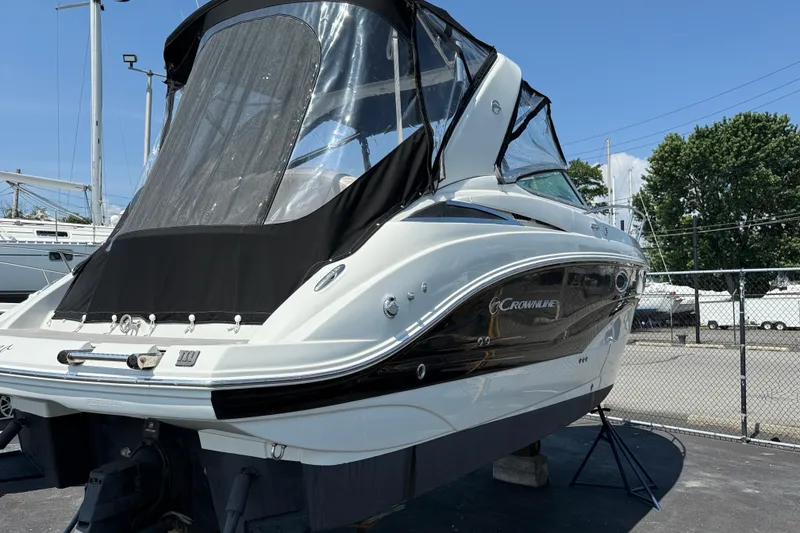Slide: The Image of 2016 Crownline 264 CR boat with black canopy, docked outdoors. - 3