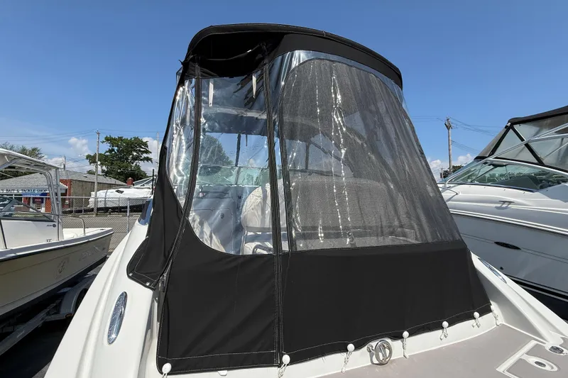 Slide: The Image of 2016 Crownline 264 CR boat with black canopy, docked under clear blue sky. - 4