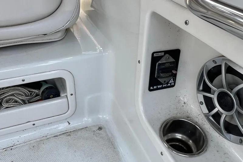 Slide: The Image of Interior of 2016 Crownline 264 CR boat with speaker, cup holder, and rope storage. - 7